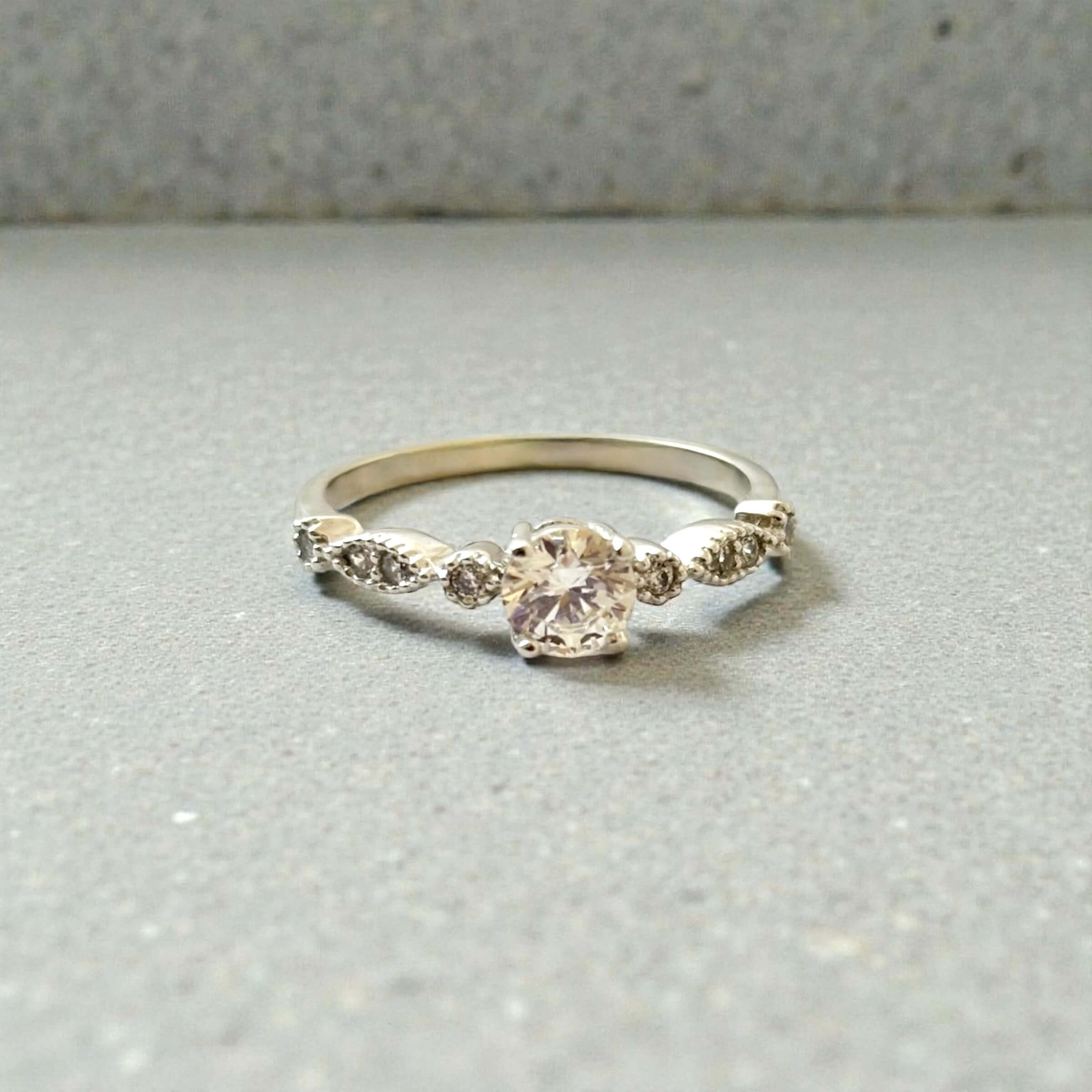 Λευκόχρυσο μονόπετρο δαχτυλίδι με κεντρική και πλαϊνές πέτρες ζιργκόν , κ14